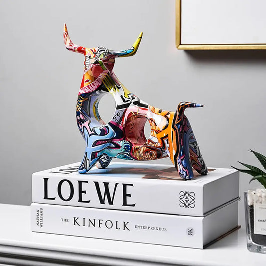 Modern Art Graffiti Cow Figurine on white books in stylish home decor setting.